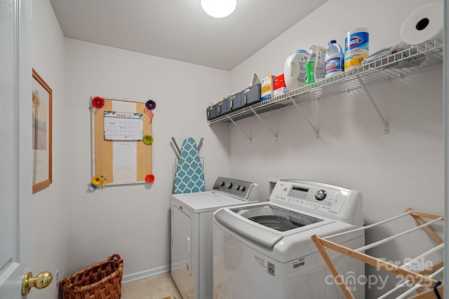 laundry room featuring laundry area, independent washer and dryer, light tile patterned flooring, and baseboards