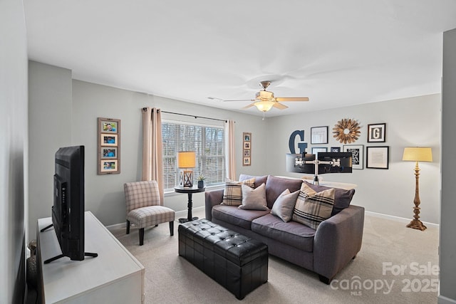 living room with light colored carpet, ceiling fan, and baseboards