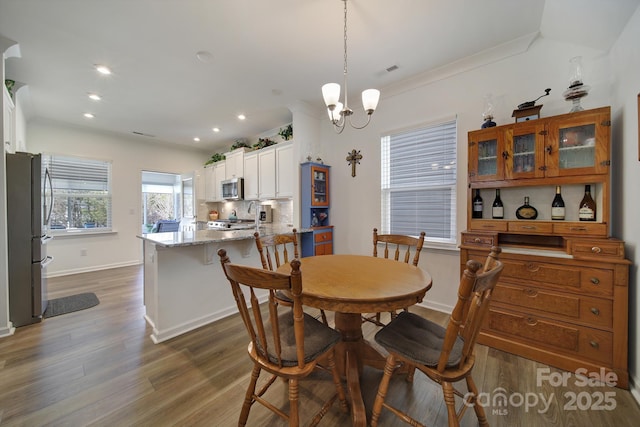 dining space with baseboards, dark wood-style floors, crown molding, a chandelier, and recessed lighting