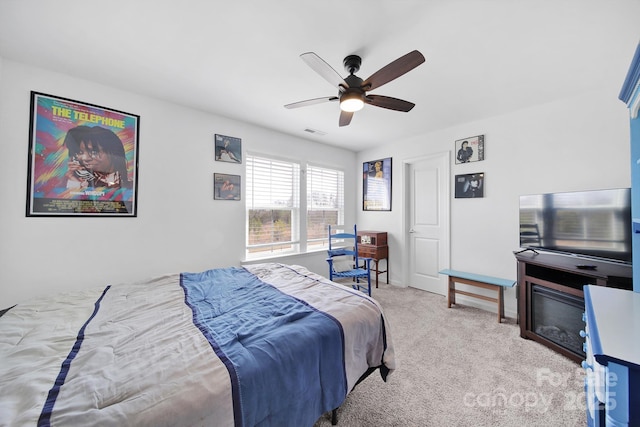 bedroom featuring ceiling fan, visible vents, and light colored carpet