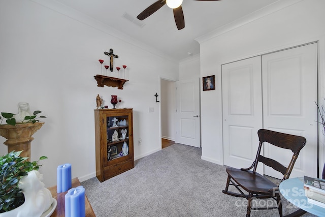 living area with carpet floors, baseboards, visible vents, and ornamental molding