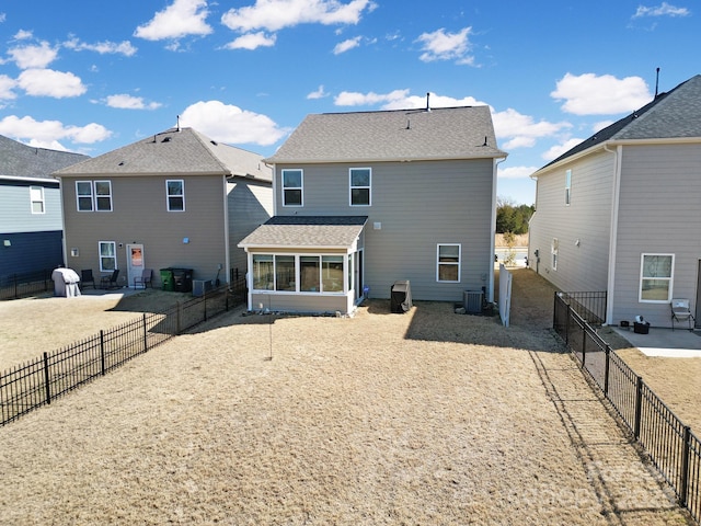 back of house with central AC unit, a fenced backyard, and a sunroom