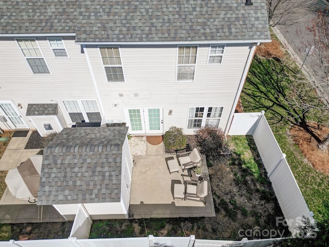 back of house featuring a patio area, a shingled roof, and a fenced backyard