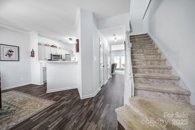 staircase with baseboards and wood finished floors