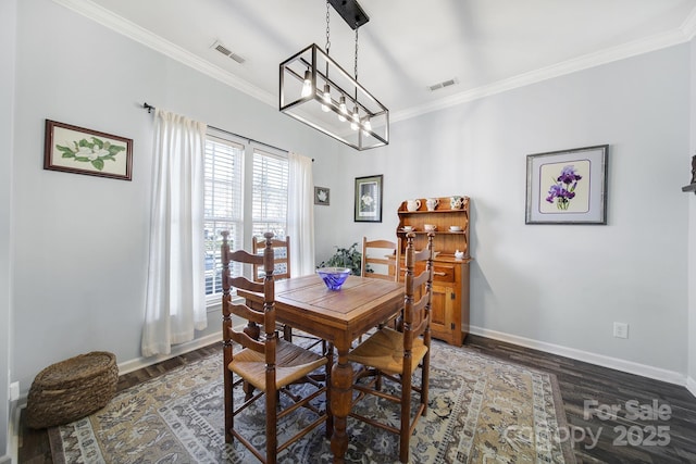 dining room with baseboards, visible vents, dark wood finished floors, and crown molding