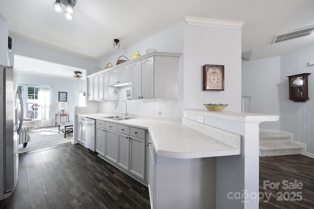 kitchen with visible vents, appliances with stainless steel finishes, a peninsula, light countertops, and a sink