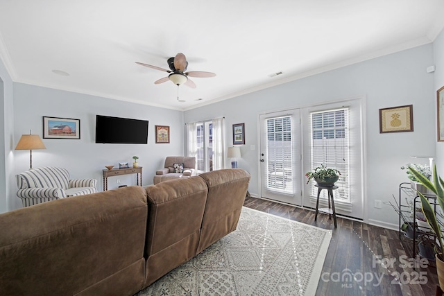 living room featuring baseboards, visible vents, dark wood finished floors, ceiling fan, and crown molding