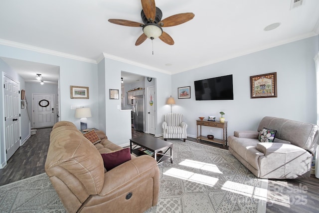 living area with baseboards, visible vents, a ceiling fan, and ornamental molding