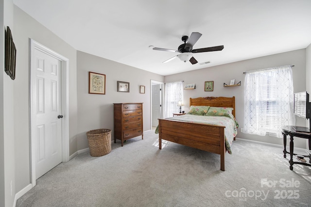 bedroom featuring light carpet, baseboards, visible vents, and a ceiling fan