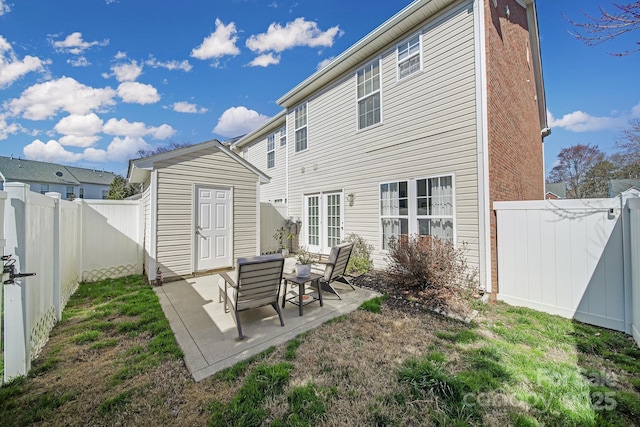 back of house featuring a patio area, a fenced backyard, and an outdoor structure