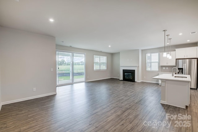 2656 Tillman St, Monroe, NC 28112 - unfurnished living room with dark wood-type flooring, a fireplace with flush hearth, a sink, baseboards, and recessed lighting