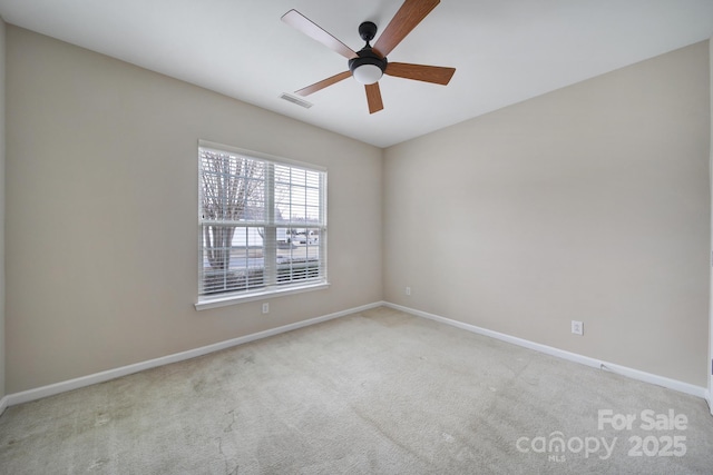 carpeted spare room with visible vents, ceiling fan, and baseboards