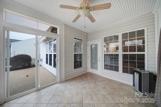 unfurnished sunroom featuring a ceiling fan