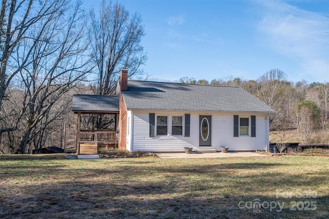 single story home featuring a shingled roof, a chimney, and a front lawn