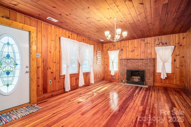 unfurnished living room with light wood finished floors, plenty of natural light, a fireplace, and visible vents