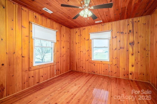 unfurnished room with wood ceiling, wood finished floors, visible vents, and a ceiling fan