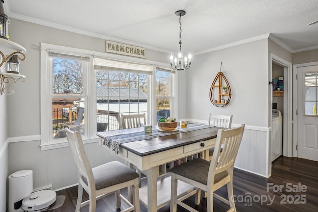 dining room featuring dark wood-style flooring, a notable chandelier, ornamental molding, wainscoting, and a textured ceiling