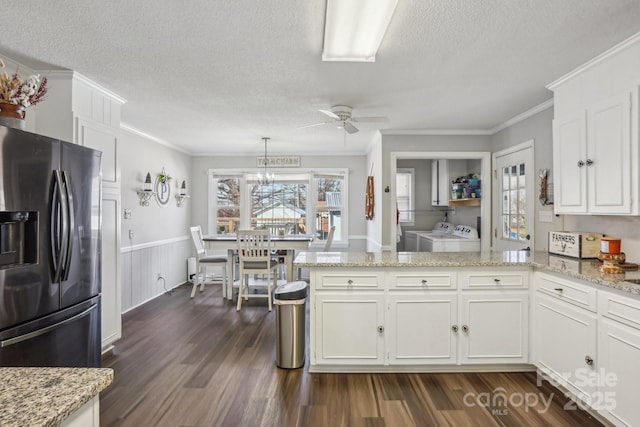 kitchen with white cabinetry, stainless steel refrigerator with ice dispenser, washer and clothes dryer, and a peninsula