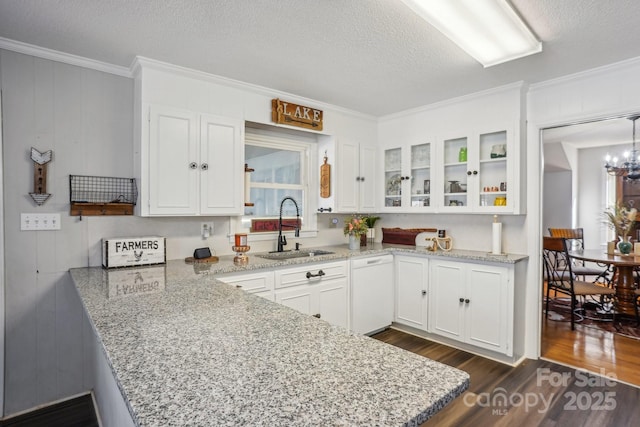 kitchen with white cabinets, glass insert cabinets, dark wood-style flooring, crown molding, and a sink