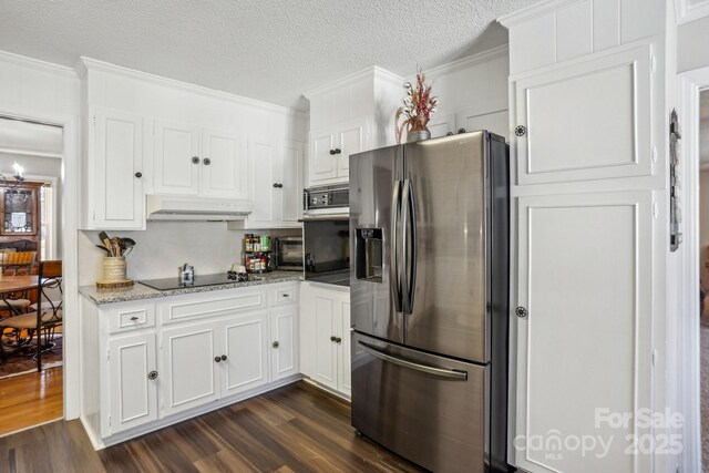 kitchen featuring appliances with stainless steel finishes, white cabinets, dark wood finished floors, and under cabinet range hood