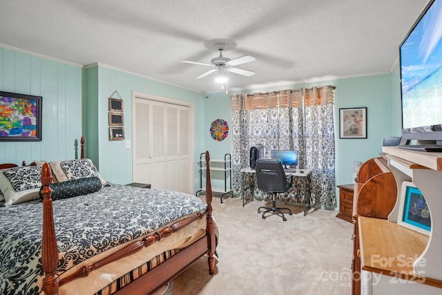 bedroom featuring carpet floors, ornamental molding, a closet, and a ceiling fan