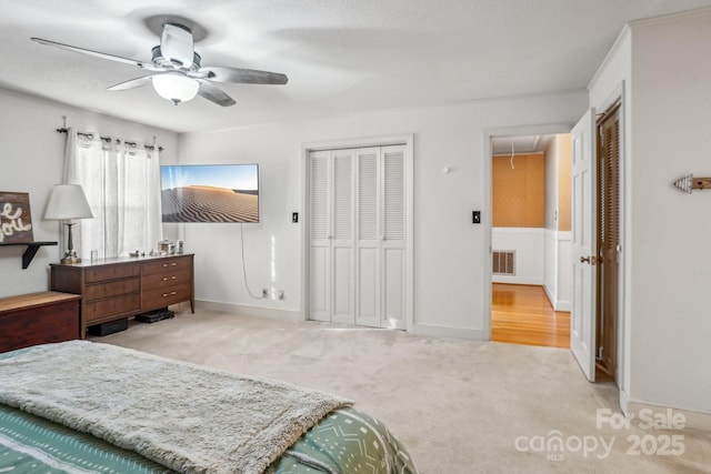 bedroom featuring attic access, light colored carpet, and ceiling fan