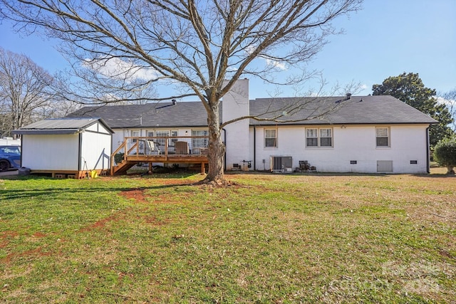 rear view of property featuring a deck, central AC, a yard, crawl space, and a storage unit