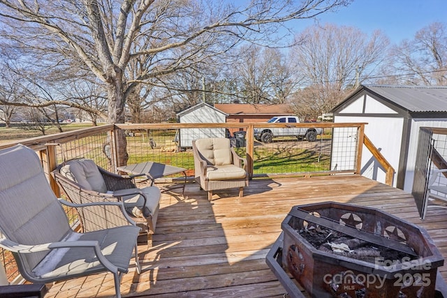 wooden deck featuring a fire pit and an outdoor structure