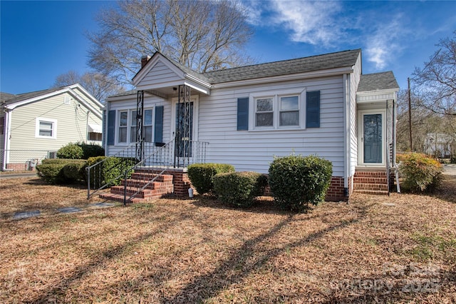 view of front of house with entry steps and a shingled roof