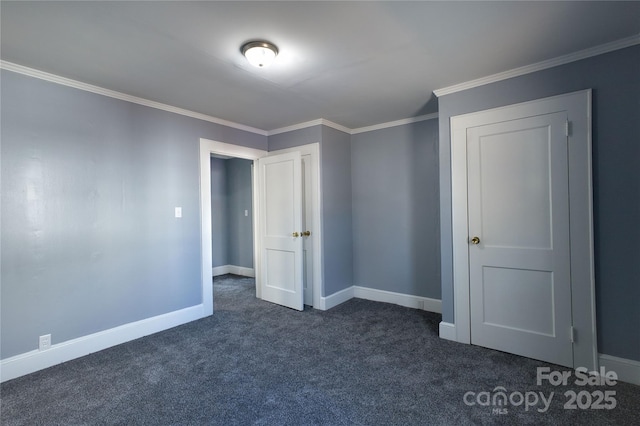 unfurnished bedroom featuring baseboards, dark carpet, and crown molding