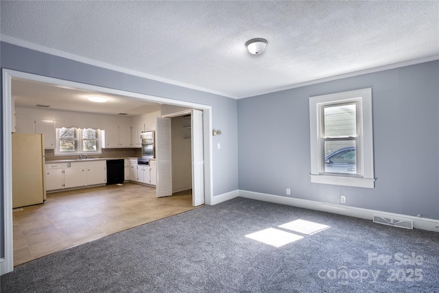 unfurnished living room featuring light carpet, a sink, visible vents, and baseboards