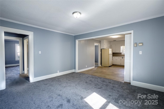 unfurnished living room featuring carpet, a textured ceiling, baseboards, and crown molding