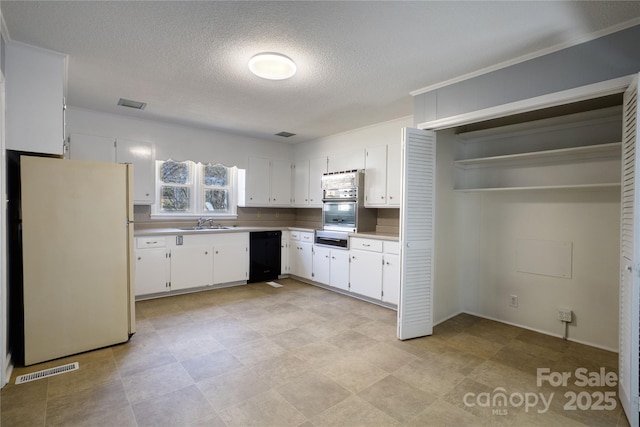 kitchen featuring light countertops, freestanding refrigerator, white cabinets, stainless steel oven, and dishwasher