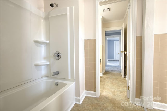 bathroom with  shower combination, a wainscoted wall, visible vents, and tile walls
