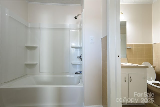 full bathroom with toilet, vanity, tile walls, washtub / shower combination, and crown molding
