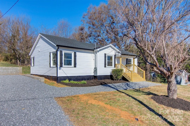 view of front of property with crawl space, driveway, a front yard, and roof with shingles