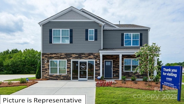 craftsman-style home with stone siding and a front lawn