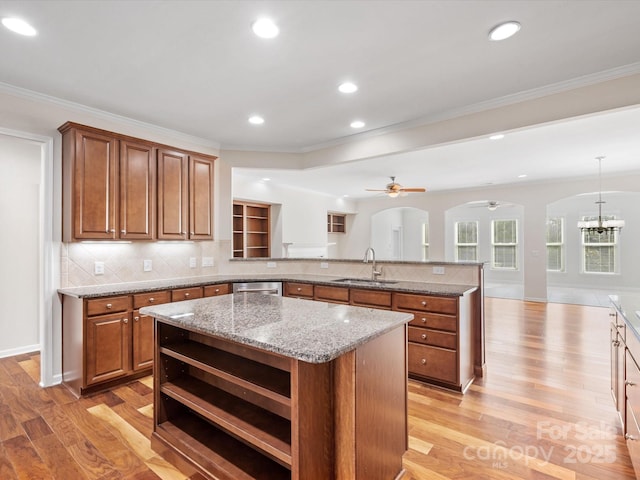 kitchen with a center island, brown cabinets, open shelves, a sink, and a peninsula