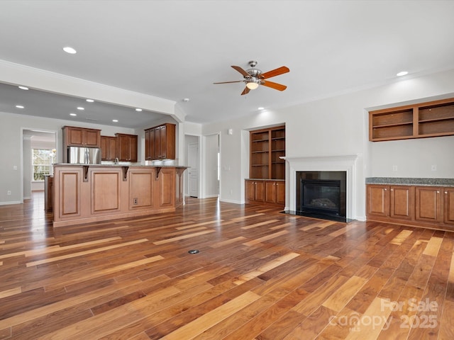 unfurnished living room with light wood-type flooring, a fireplace with flush hearth, and recessed lighting