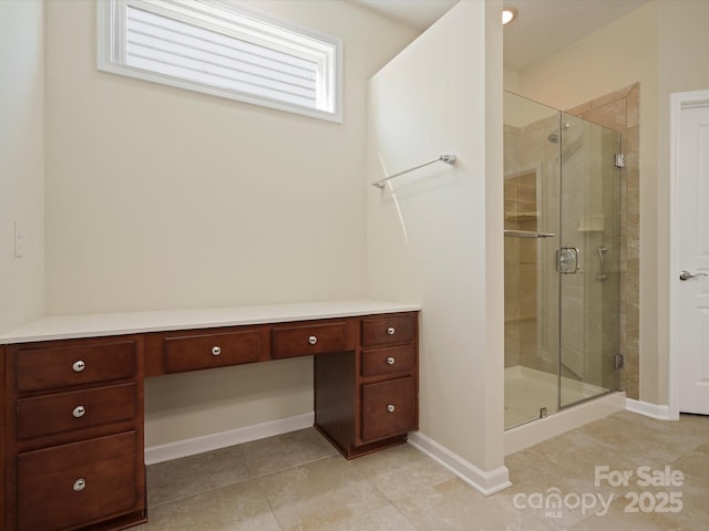 bathroom featuring a stall shower, tile patterned flooring, and baseboards