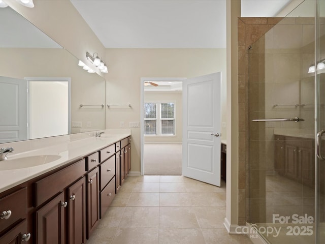 full bathroom with double vanity, tile patterned floors, a sink, and a shower stall