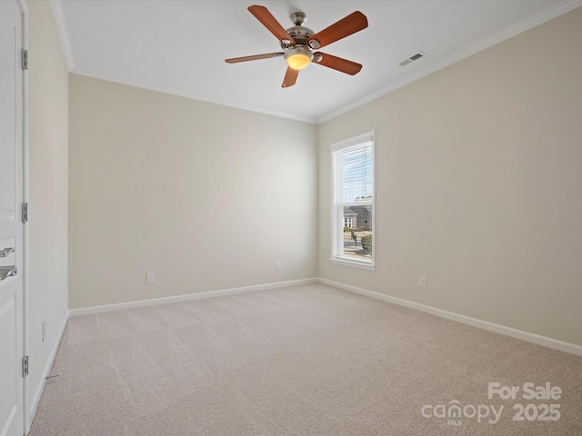 spare room with baseboards, light colored carpet, visible vents, and crown molding