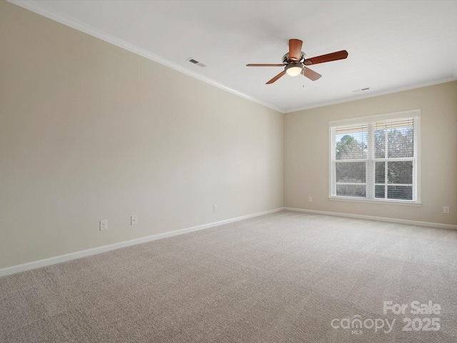 empty room featuring baseboards, visible vents, light colored carpet, and crown molding