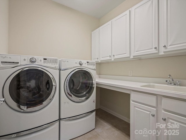 laundry room with cabinet space, separate washer and dryer, a sink, and light tile patterned flooring