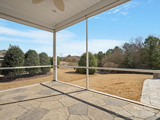 unfurnished sunroom featuring ceiling fan