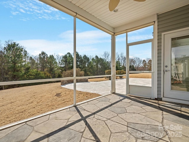 unfurnished sunroom with a ceiling fan