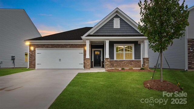 447 Zender Ln, Monroe, NC 28112 - craftsman-style house with an attached garage, driveway, a yard, and stone siding
