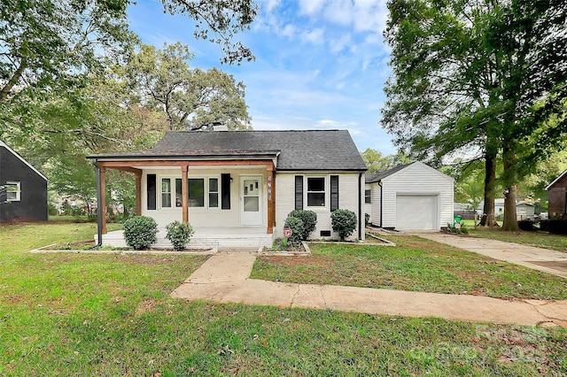 bungalow with concrete driveway, an outbuilding, a front yard, a porch, and brick siding