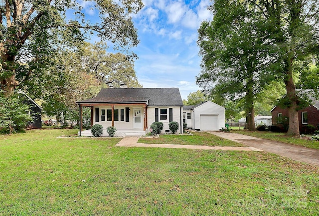 view of front facade with a garage, an outbuilding, driveway, and a front yard