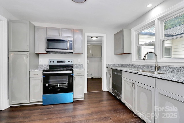 kitchen featuring dishwashing machine, dark wood-style flooring, a sink, electric range oven, and stainless steel microwave